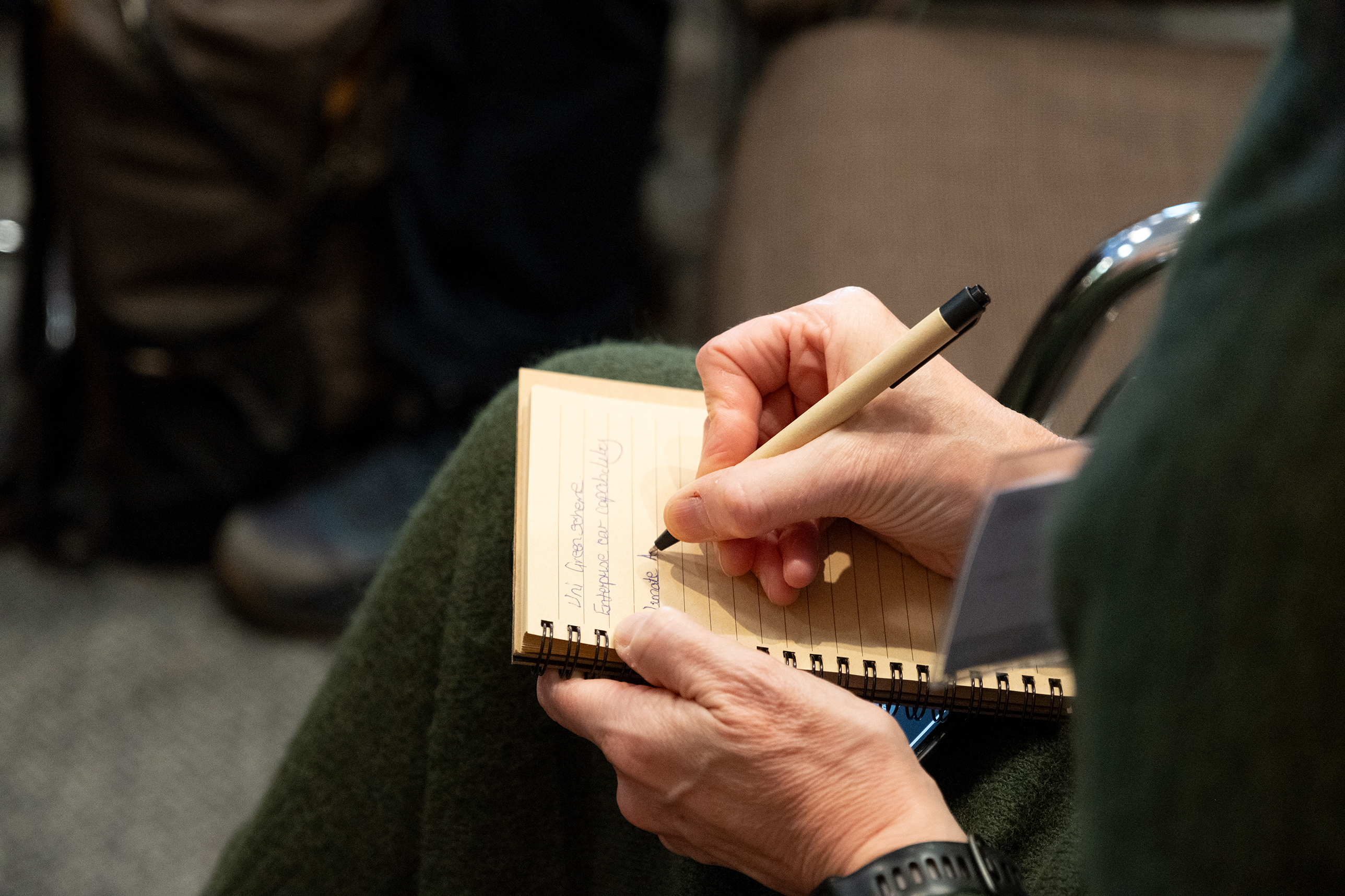 A person writing in a notepad. 