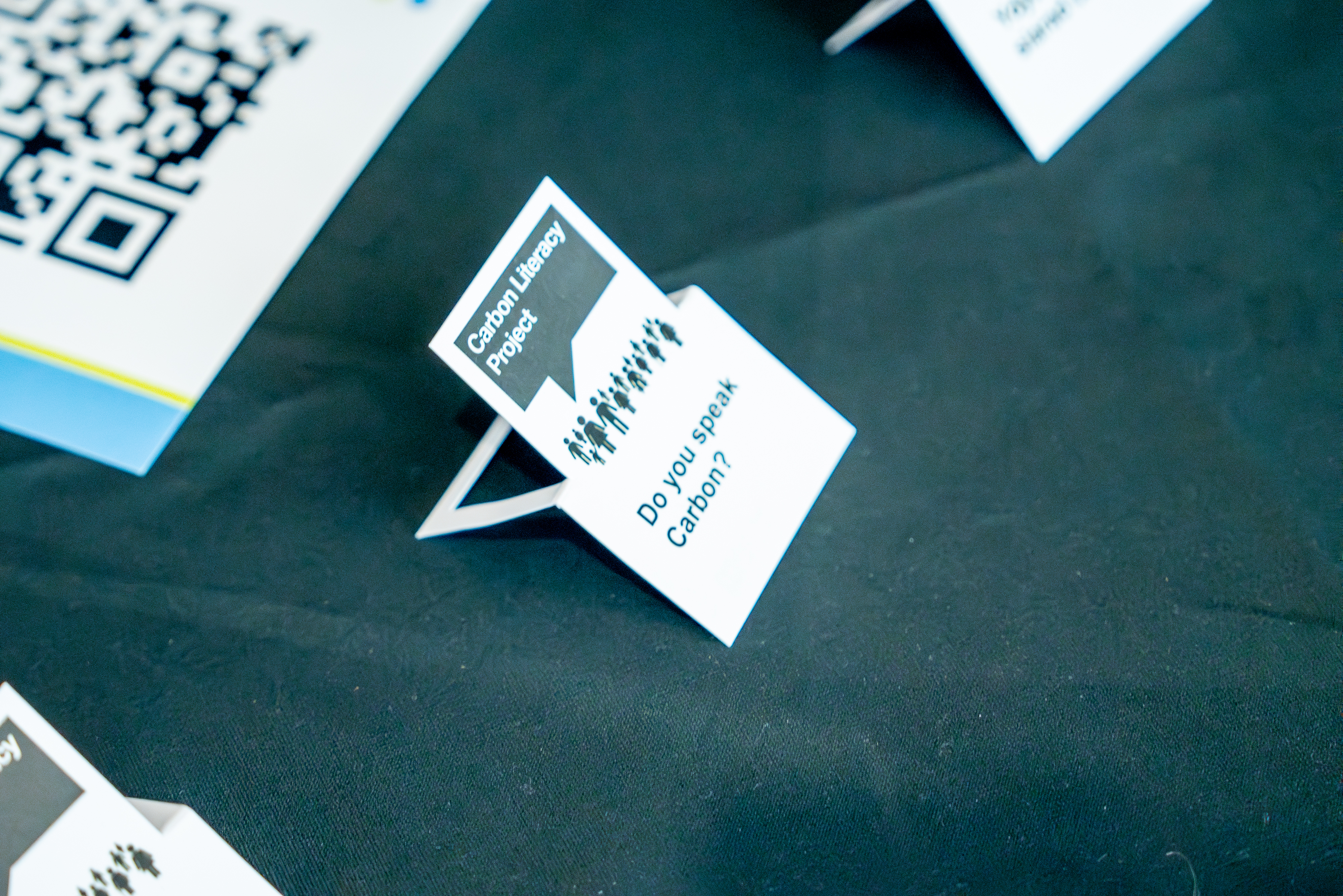 A cardboard Carbon Literary sign in black and white reading Do you speak carbon? 