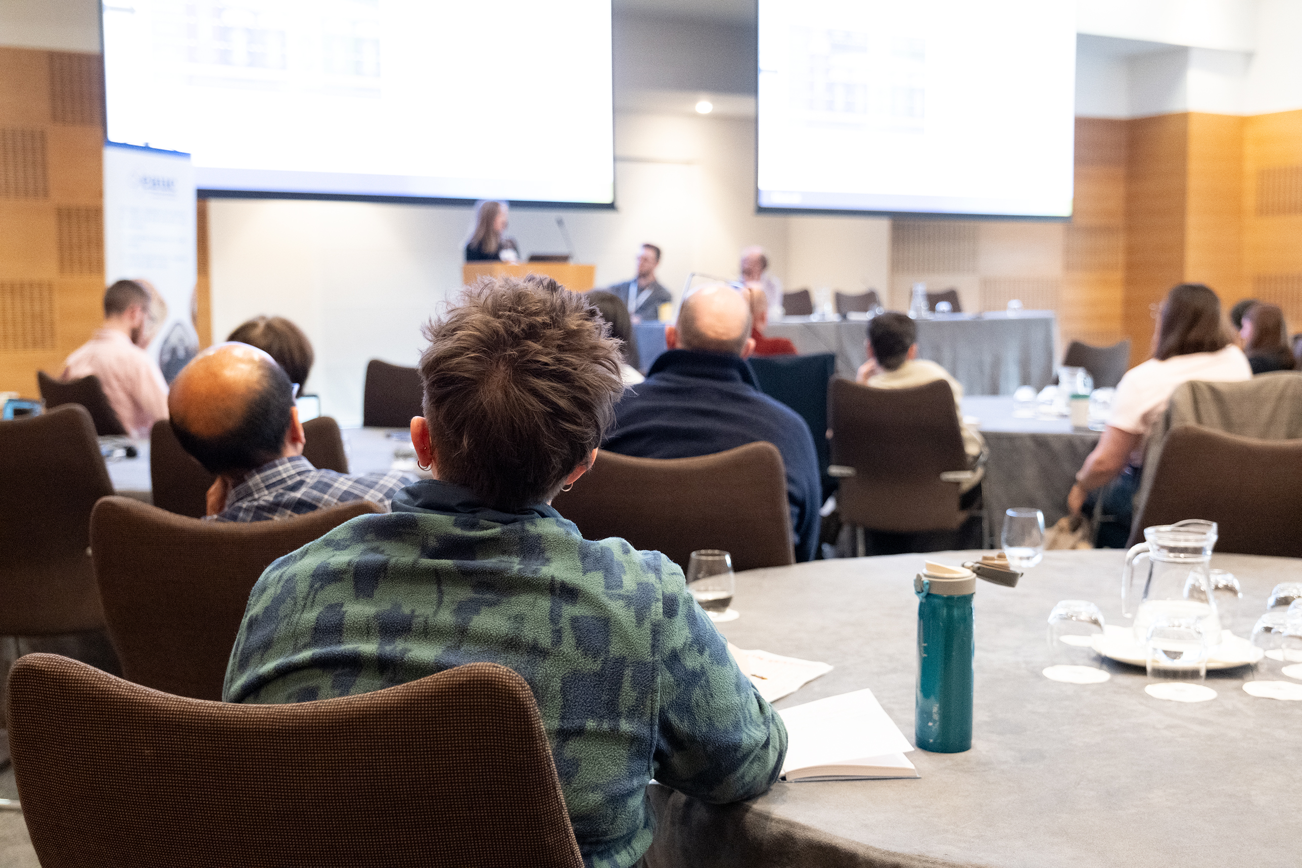 A person watching a presentation at a conference. 