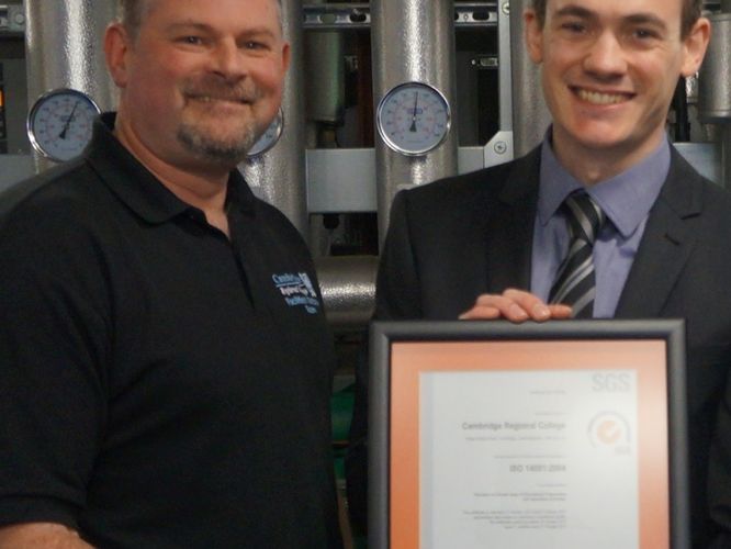CRC Operations Manager Mark Neville, left, is presented with the college’s ISO accreditation by Stephen Davies of Systems & Services Certification.