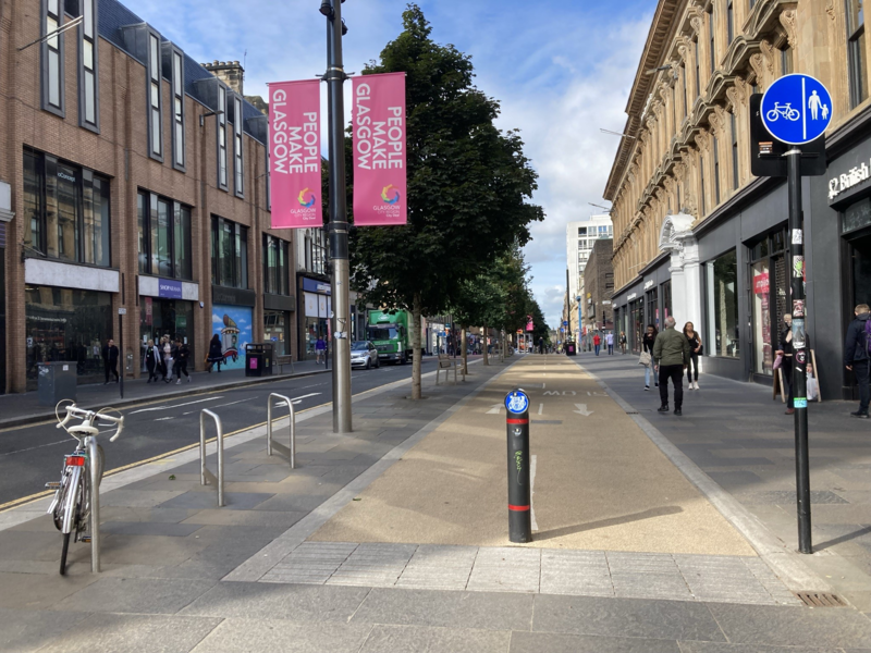 Glasgow active travel scene including wide pavements and segregated cycling infrastructure.