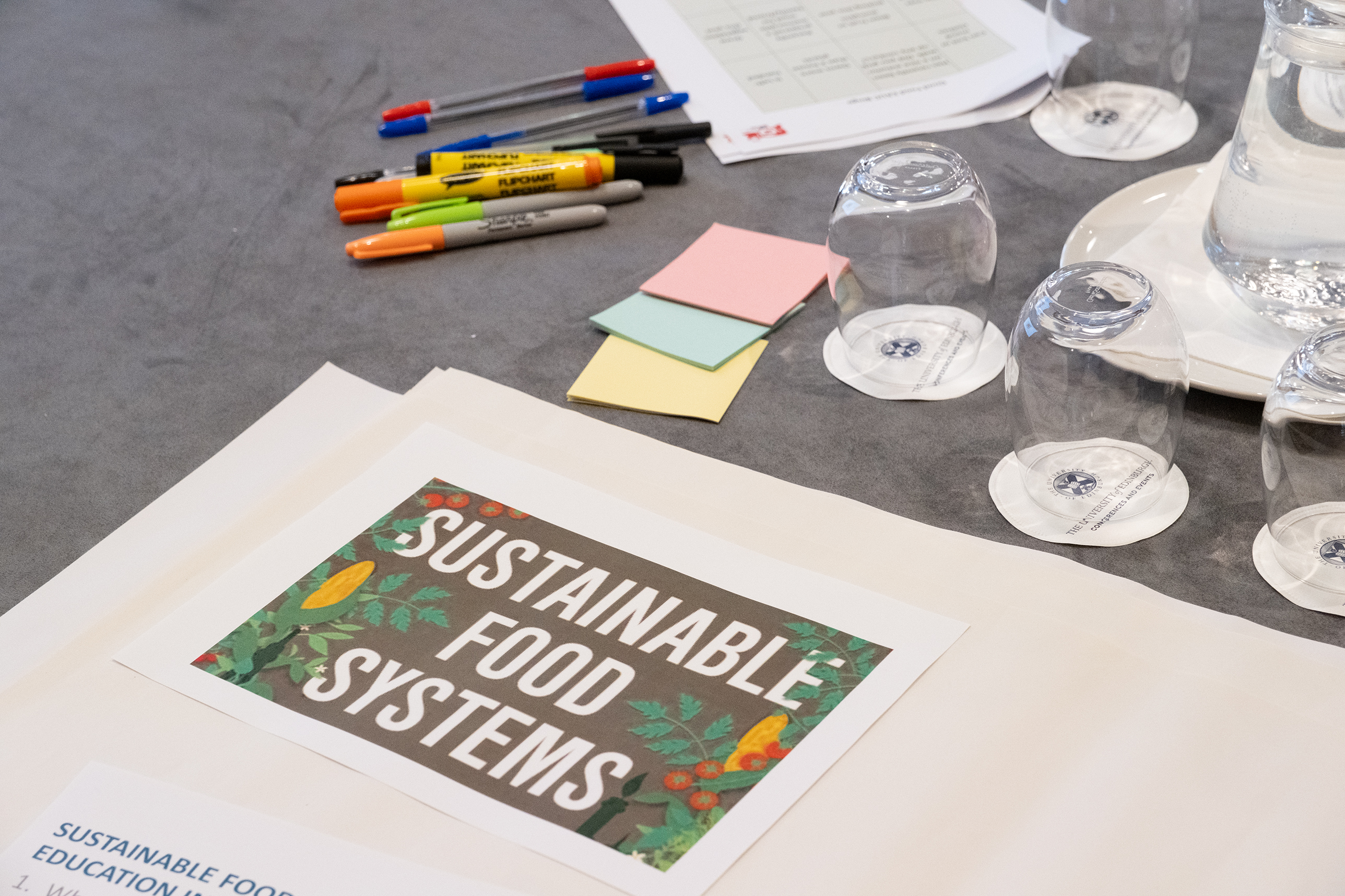 Sustainable food systems poster surrounded by post-its and pens.