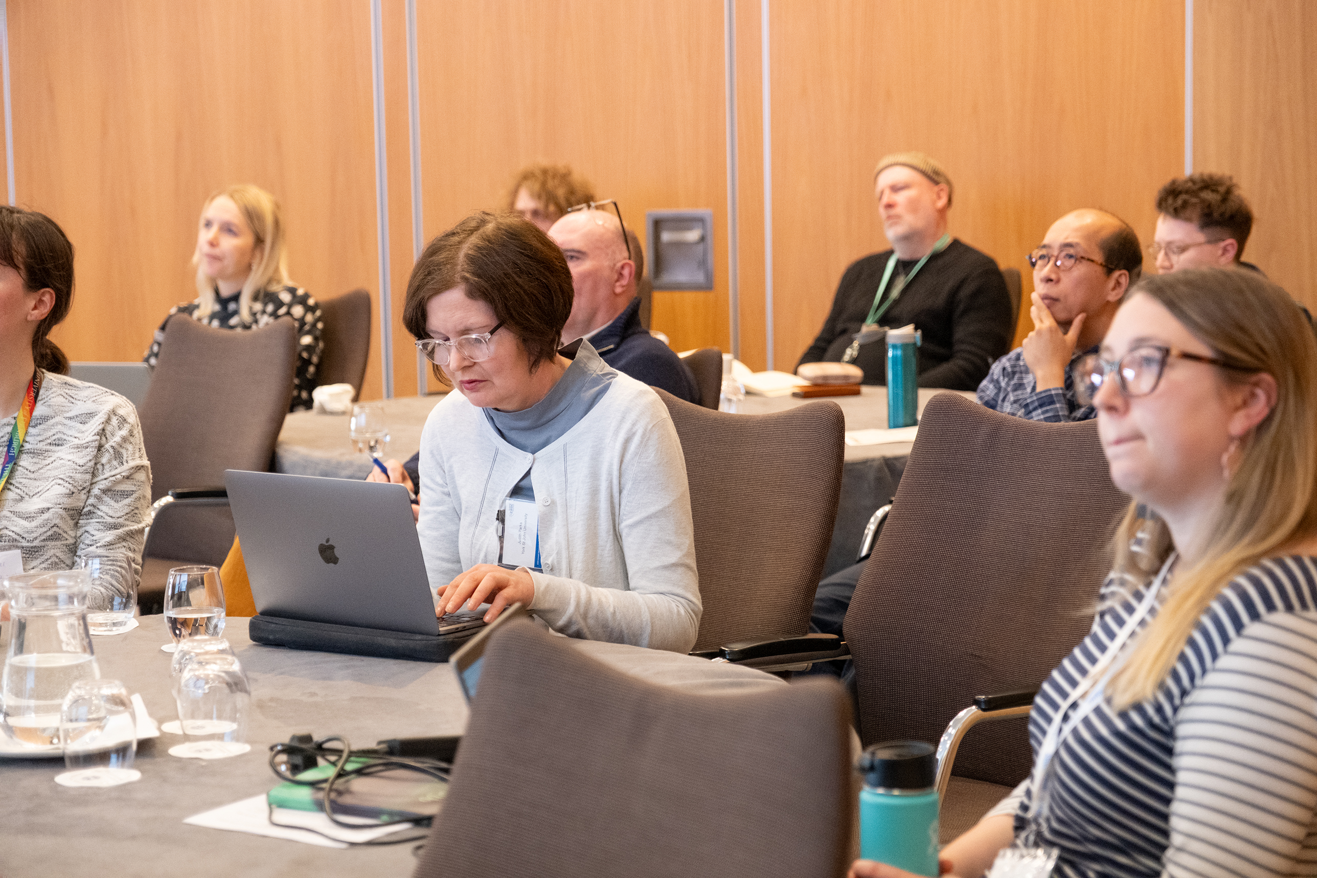 A group of people listening to a conference session. 